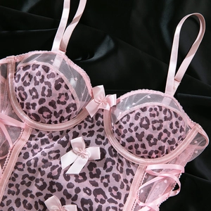 Dettaglio del body in pizzo leopardato rosa con fiocchi di raso e coppe con ferretto