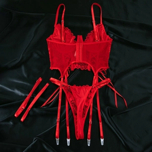 Detailed flat lay of red lace lingerie set with satin garters and G-string on black silk