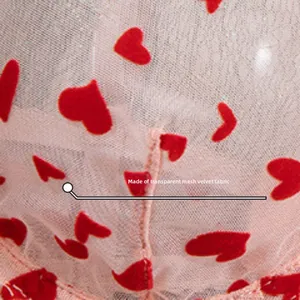 Détail du tissu en maille rose transparente avec motif de cœurs rouges floqués