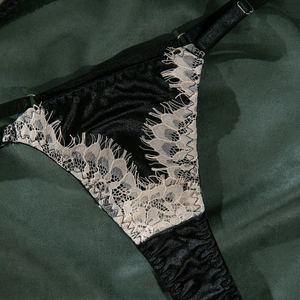 Détails de la dentelle crème et du satin noir sur ce slip de lingerie sexy