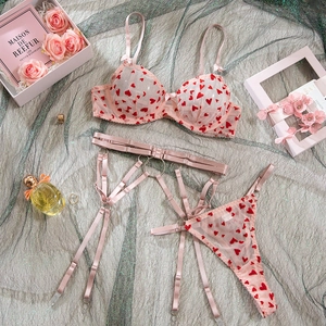 Détail à plat d'un ensemble de lingerie en mesh rose avec broderie de coeurs rouges