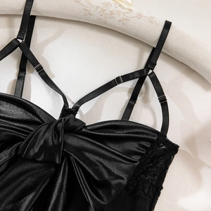 Close-up of black satin lingerie featuring a large bow, lace details, and adjustable straps
