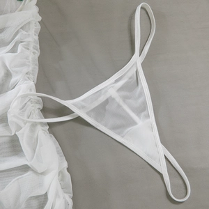 Detail of white mesh lace lingerie showing sheer pleated fabric and strappy thong texture