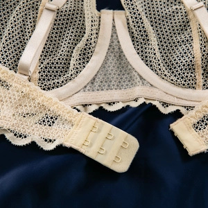 Détail d'un soutien-gorge en maille dentelle avec bretelles et fermeture à trois crochets