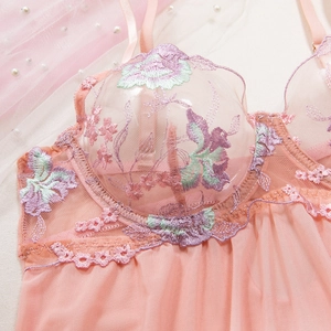 Close-up of floral embroidery on pink mesh lace nightdress with delicate pearl accents