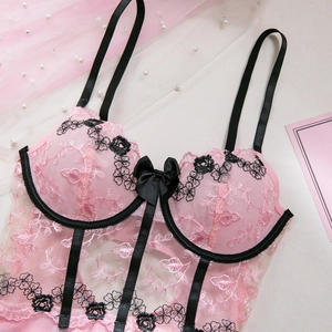 Détail de broderies florales roses et tulle sur un ensemble de lingerie en dentelle