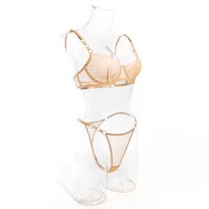 Dettaglio del set lingerie in mesh con anelli metallici su tessuto trasparente su manichino
