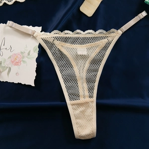 Détail d'un string en dentelle transparente avec bretelles réglables et bords festonnés