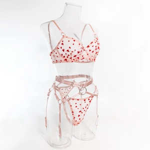 Détail de l'ensemble lingerie en résille rose à cœurs rouges et porte-jarretelles