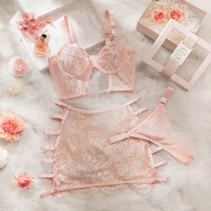 Flat lay of pink lace lingerie set with wired bra and skirt on pearl mesh background