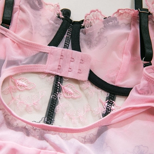 Détail de lingerie en dentelle florale rose avec bretelles noires et agrafes dorsales