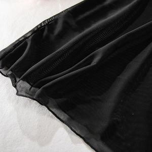 Detailed macro view of black sheer mesh fabric with delicate hem stitching and texture