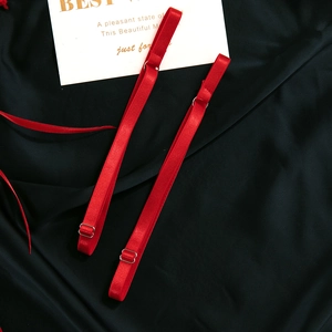 Close-up of adjustable vibrant red lingerie straps with metal buckles on silk
