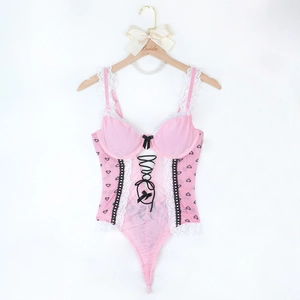 Dettaglio del body in rete rosa con stampa a cuori, pizzo e fiocco decorativo