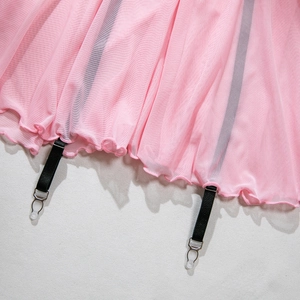 Détail de l'ourlet en tulle rose avec jarretelles noires réglables et pinces métal