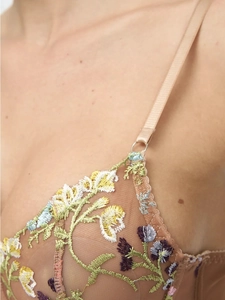 Detailed view of floral embroidery on sheer mesh lingerie with adjustable straps
