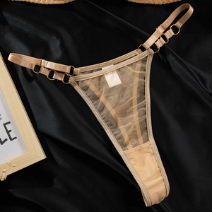Dettaglio del perizoma beige in mesh trasparente con anelli decorativi in metallo dorato