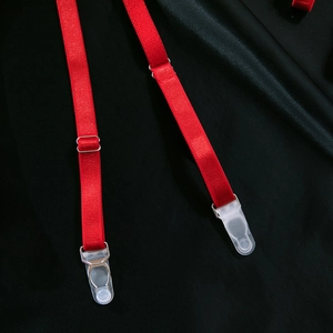 Close-up of red elastic garter belt straps with silver metal adjusters on black satin