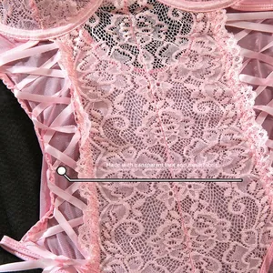Detail of pink floral lace and silk ribbon lacing on a mesh bodysuit with sheer texture
