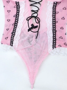 Dettaglio del body in mesh rosa con stampa a cuori, pizzo e fiocco decorativo