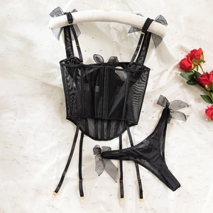 Detail of black corset lingerie with mesh texture, fishbone support and bow straps
