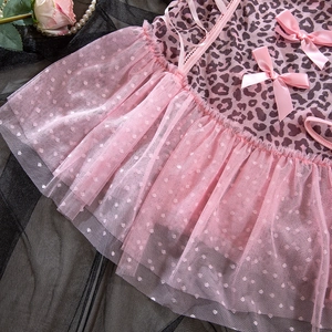 Détail de la robe en tulle léopard rose avec nœuds satinés et ourlet à volants pointillés