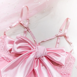 Close-up of pink satin lingerie with a large bow and delicate lace detailing