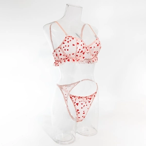 Ensemble soutien-gorge en maille rose avec cœurs rouges et volants sur un mannequin