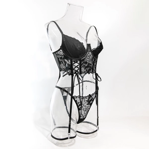 Detailed close-up of black lace lingerie set with floral embroidery and criss-cross ties