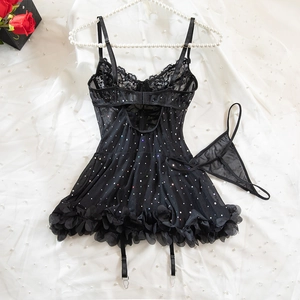 Close-up of black lace mesh lingerie set with sequins and pearls as background
