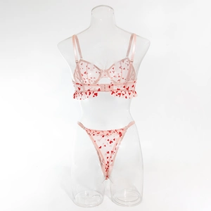 Vue détaillée d'un ensemble de lingerie rose en tulle avec cœurs rouges et volants