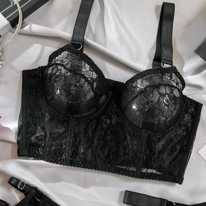 Detail of black lace corset bra with floral patterns and adjustable straps on silk