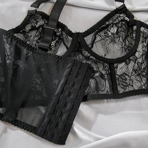 Detailed close-up of black lace corset back with adjustable straps and hook-eye closures