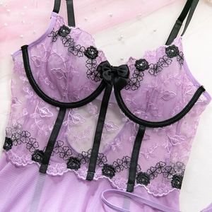 Détail de lingerie en maille violette avec broderie florale et finitions en satin noir
