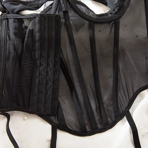 Detail of black mesh corset with boning support and adjustable metal side buckles