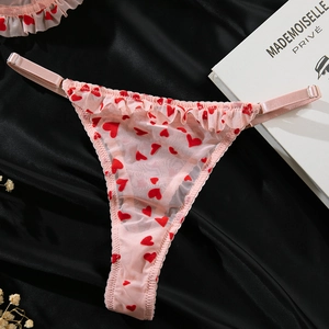 Vue détaillée d'un string en mesh rose avec flocage cœurs rouges et sangles réglables