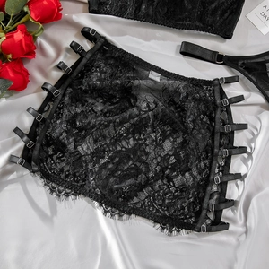 Detailed view of black lace lingerie dress with adjustable metal buckles on silk fabric