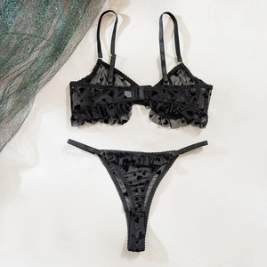Détail d'un ensemble lingerie en mesh noir avec motifs cœurs velours et bords plissés