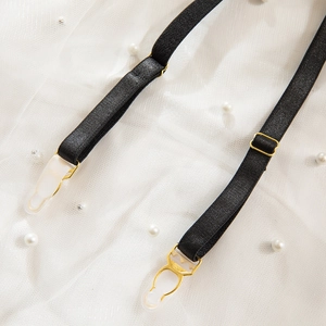 Detailed view of adjustable black garter straps with gold buckles and white plastic clips