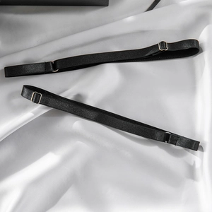 Detail of adjustable black elastic lingerie straps with silver metal hooks on silk