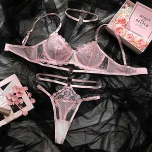 Détail à plat d'un ensemble lingerie en dentelle rose avec détails cœur et broderies