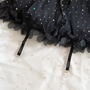 Detail of black mesh lace hem with shimmering rhinestones and adjustable garter straps