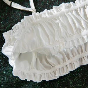 Detail of white ruffled camisole with pleated fabric and adjustable metal strap slider