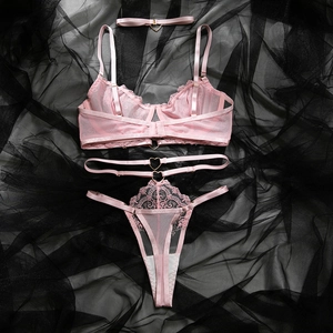 Détail d'un ensemble de lingerie en dentelle rose avec boucles coeur en métal