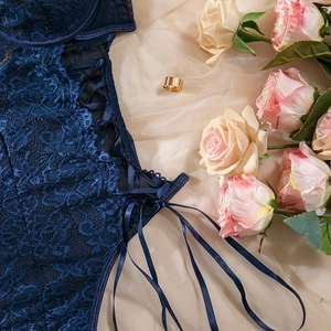 Close-up of dark blue floral lace bodysuit with side criss-cross ribbon and metal eyelets