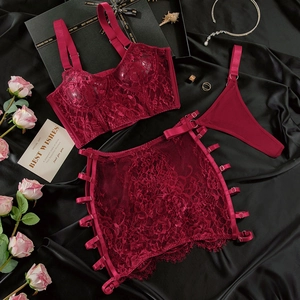 Detailed flat lay of a dark red lace lingerie 3-piece set with a silky black background