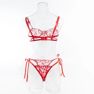 Dettaglio completo di lingerie in pizzo rosso con ricamo a cuore e fiocchi