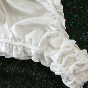 Detail of white ruffled lingerie fabric with elastic edges and fine stitching texture
