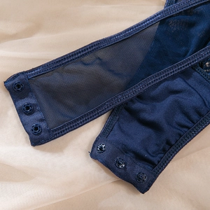Macro detail of dark blue lace bodysuit showing triple snap button crotch closure