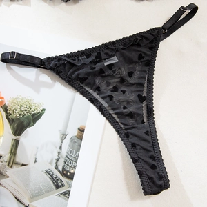 Détail d'un string en tulle noir avec cœurs floqués et bretelles réglables